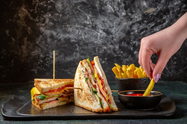 Deliciosos sanduíches de presunto com batata frita na superfície escura