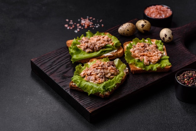 Deliciosos sanduíches frescos com salada de salmão em conserva torrada e ovos de codorna