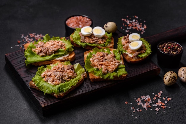 Deliciosos sanduíches frescos com salada de salmão em conserva torrada e ovos de codorna