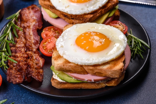 Deliciosos sándwiches frescos con huevo frito jamón mantequilla aguacate y semillas de sésamo