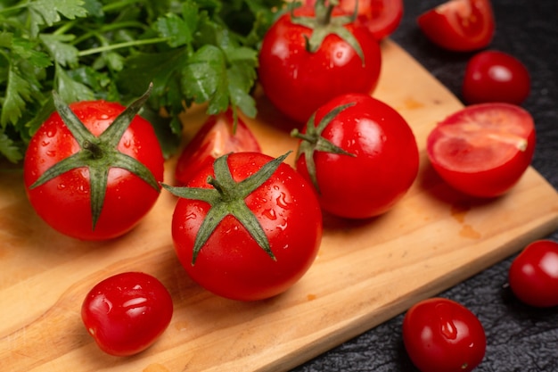 Deliciosos tomates e ervas na mesa de madeira