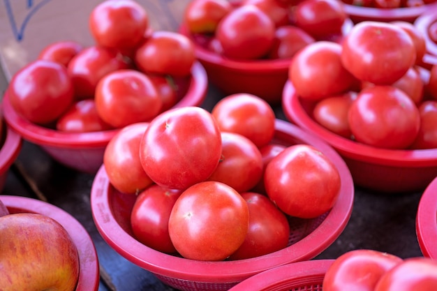 Deliciosos tomates frescos alimentos vegetales de frutas en una cesta de plástico rojo en la tarde del mercado tradicional de Seúl, Corea del Sur concepto de cosecha de cerca