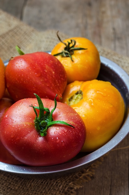 Deliciosos tomates vermelhos e amarelos em uma tigela.