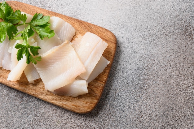 Delikatesse Fisch geräucherter Heilbutt serviert mit Petersilie zum Essen auf Holzschneidebrett Nahaufnahme