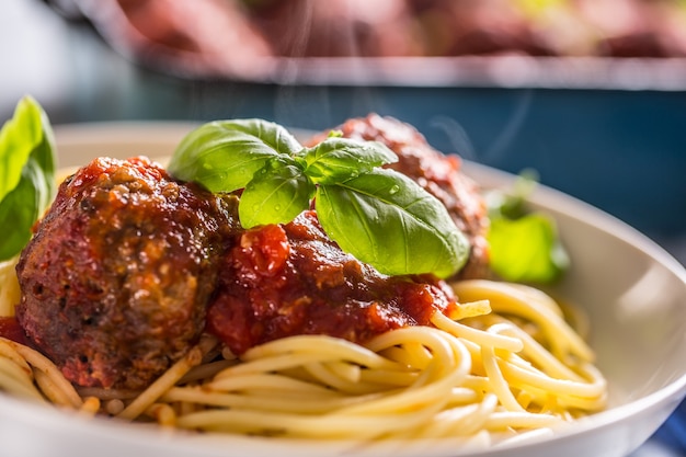 Delisious italienische Mahlzeit Fleisch Rindfleischbällchen mit Pasta Spaghetti und Basilikum in weißer Platte.