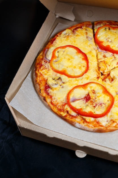 Delivery de pizza italiana. Delicioso prato de pizzaria assada no forno com mussarela, parmesão e queijo, entregue em caixa de papelão. Delicioso fast food para levar cozido no forno para o jantar.