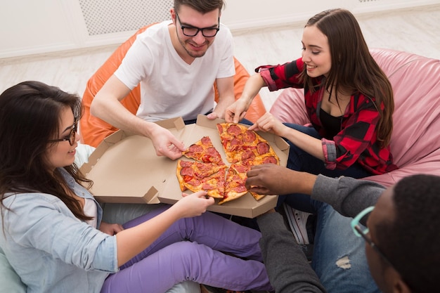 Delivery de pizza. Gente feliz almorzando en la oficina de coworking durante el descanso, cultivo, primer plano