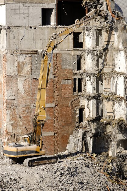 Demolição de edifício com escavadeira-destruidora