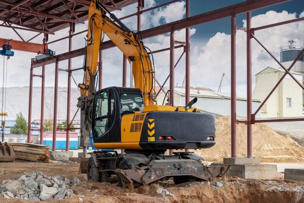 Demolição profissional de estruturas de concreto armado com martelo hidráulico industrial com escavadeira. Varas de acessórios de metal. Destroços e pedaços de concreto.