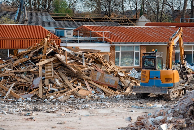 Demolición de edificio Excavadora rompe casa vieja Hacer espacio para la construcción de nuevas casas