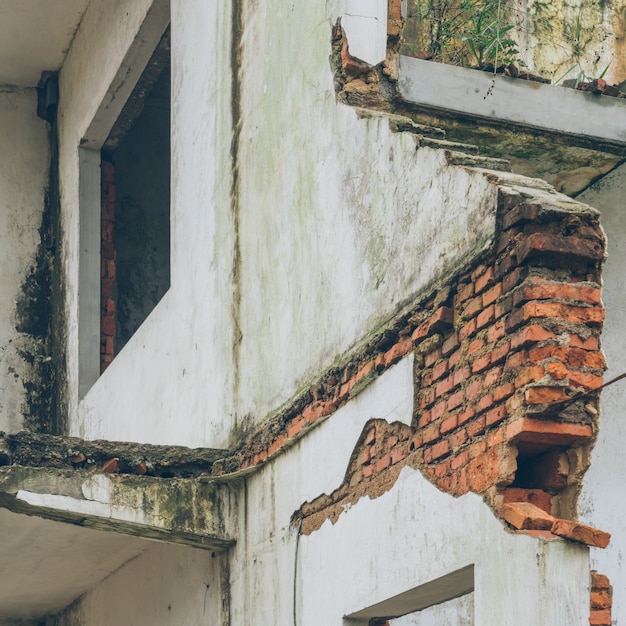 Foto demolido metade da parede de tijolos da casa em ruínas