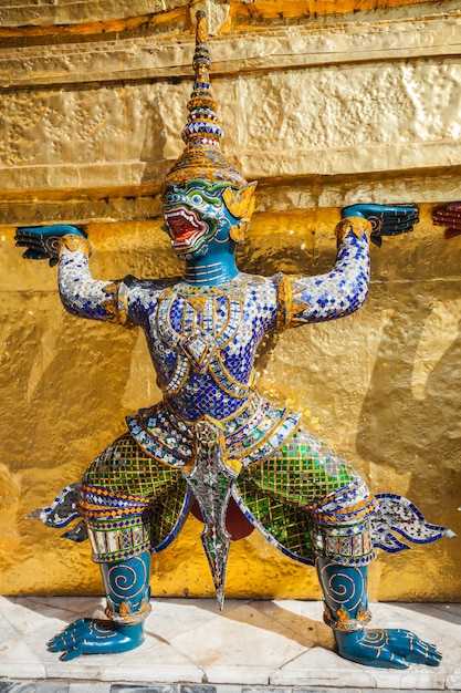 Demonio guardián sosteniendo Golden Chedi del templo Wat Phra Kaew en Bangkok, Tailandia