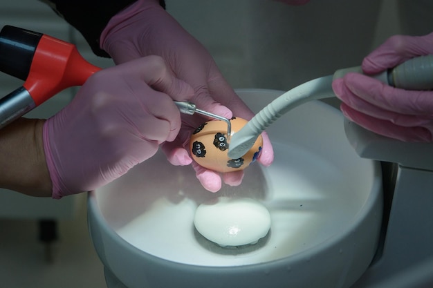 Demonstração de limpeza de um dente com jateamento em uma casca de ovo de galinha higiene dental e dentes