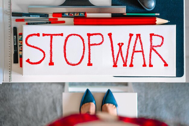 Foto demonstrantin vor einem stop-war-plakett mit rotem schild