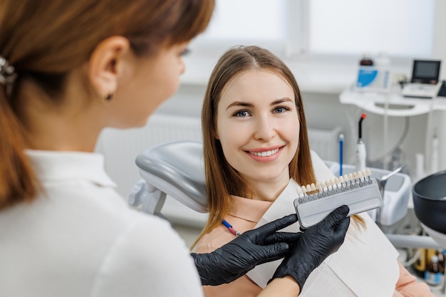 Demostración del dentista para la guía de tonos de color de los dientes del paciente para blanquear los dientes