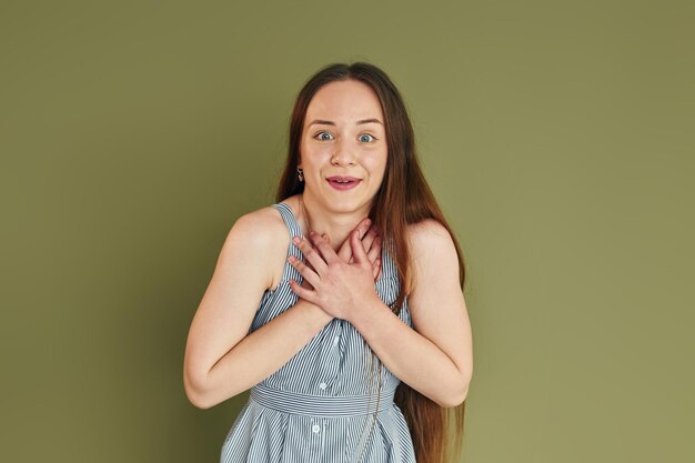 Demostración de emociones Mujer joven en ropa casual de pie en el interior del estudio