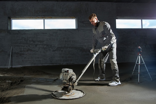 Foto den boden mit beton füllen, estrich und den boden von bauarbeitern ausgleichen. glatte böden aus einer mischung von zement und industriebeton