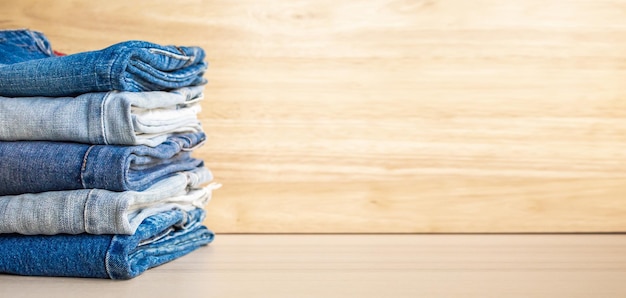 Denim-Blue-Jeans-Stapel auf Holztischhintergrund