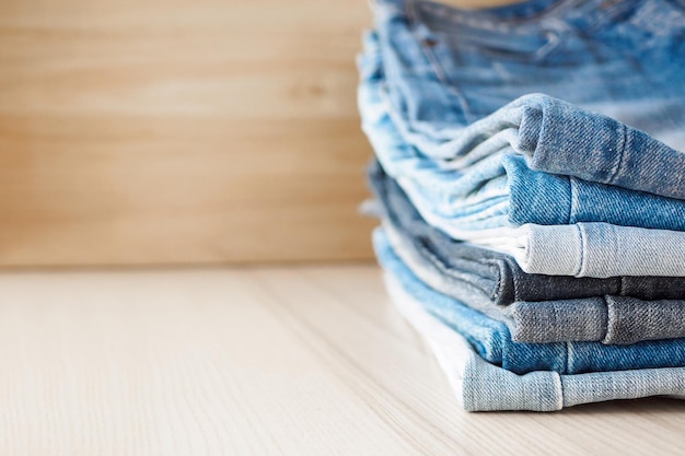 Denim-Blue-Jeans-Stapel auf Holztischhintergrund