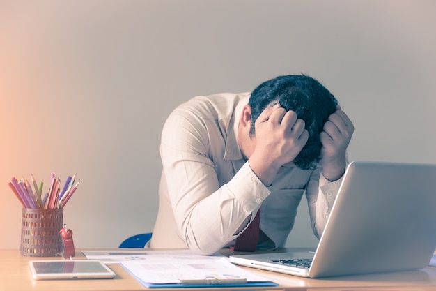 Denken Sie schwer an die Analyse in der Arbeit. Betonter junger Geschäftsmann im Büro