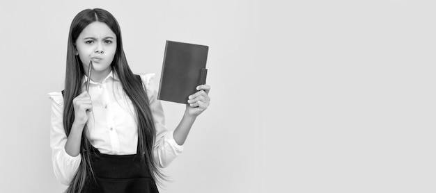 Denken Sie vor dem Studium Nachdenkliches Mädchen gelber Hintergrund Kind denken Holding Buch und Stift Schulbildung Banner der Schule Studentin Schulmädchen Schüler Porträt mit Kopie Raum