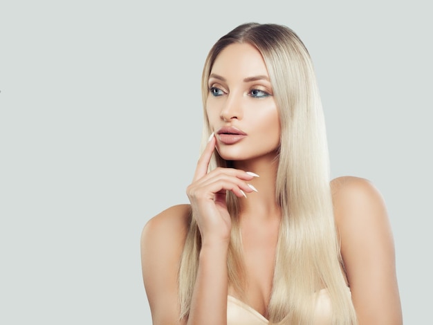 Denkende Frau mit sauberer, frischer Haut und blondem Haar im Hintergrund mit Kopierbereich Gesichtsbehandlung Kosmetologie, Schönheit, Hautpflege und Spa