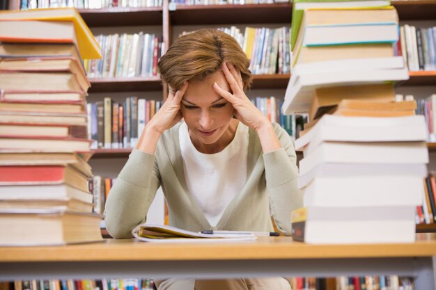 Denkender Lehrer, der an der Bibliothek sitzt