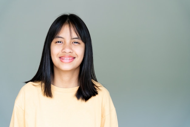 Dental Brace Girl sonriendo y mirando a la cámara, se siente feliz y tiene buena actitud con el dentista. Motivar a los niños a no tener miedo cuando tienen que ir a la clínica dental.