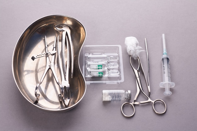 Dentalgeräte in steriler Verpackung auf grauem Hintergrund.