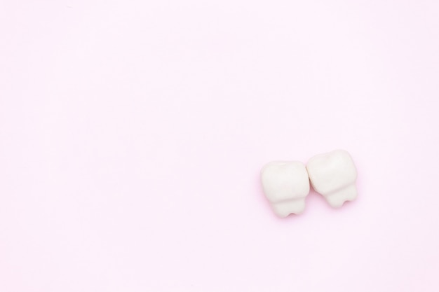 Dente branco, espaço para texto em fundo cor de rosa. conceito de dentes saudáveis.