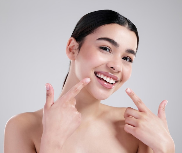 Dentes apontando e retrato de mulher em estúdio para bem-estar dental e rotina matinal Beleza do sorriso e pessoa feminina com boca limpa para tratamento de higiene bucal por fundo branco