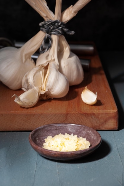 Dentes de alho em uma tábua com uma colher de pau.