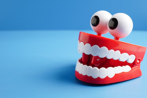 Dentes rojos divertidos con ojos modelo de prótesis de juguete para el cuidado de la salud dental