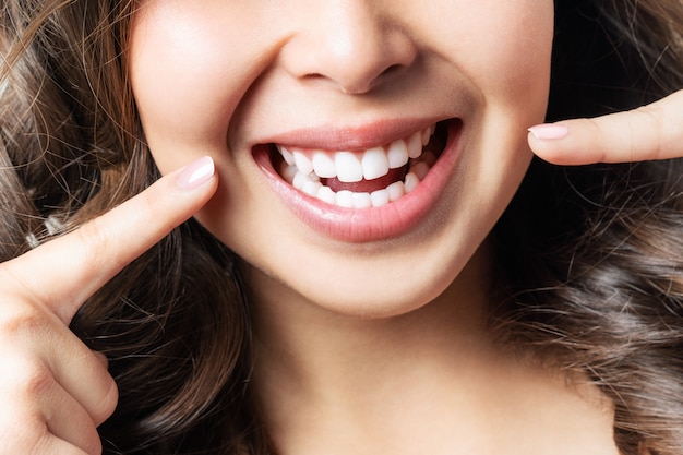 Dentes saudáveis perfeitos sorriem de uma jovem mulher. clareamento dos dentes. paciente de clínica odontológica. imagem simboliza odontologia para cuidados bucais, estomatologia