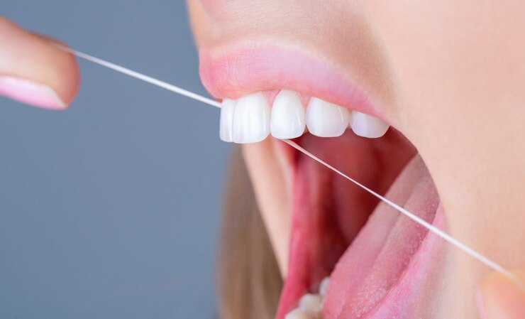Foto dentes uso do fio dental higiene bucal e cuidados de saúde mulheres sorridentes usam fio dental dentes brancos saudáveis mulher de limpeza dental usando fio dental fio dental cuidando dos dentes conceito de dentes saudáveis