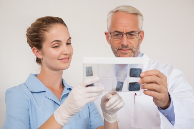 Dentista y asistente estudiando radiografías