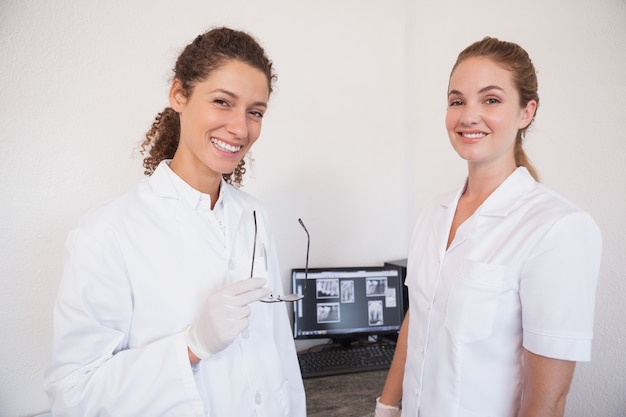 Dentista y asistente estudiando rayos x en la computadora