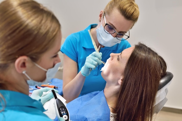 Dentista y asistente examinan al paciente