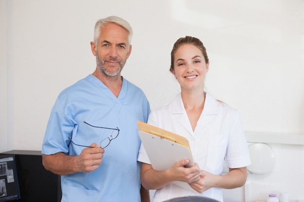 Dentista y asistente sonriendo a la cámara