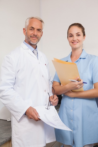 Dentista y asistente sonriendo a la cámara