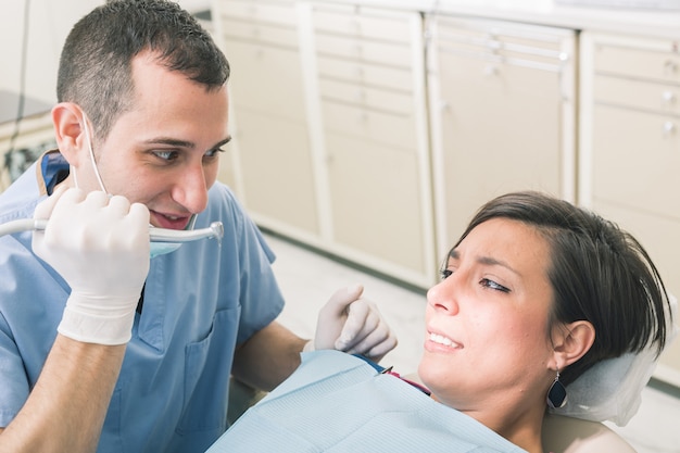 Dentista asustando al paciente con el taladro.