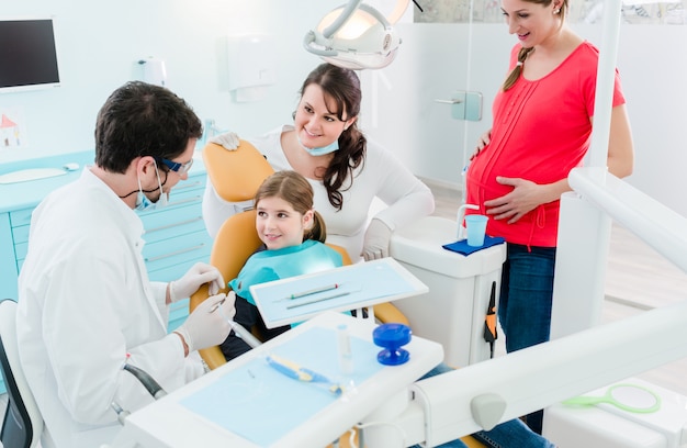 Dentista atendiendo a toda la familia en su consultorio.