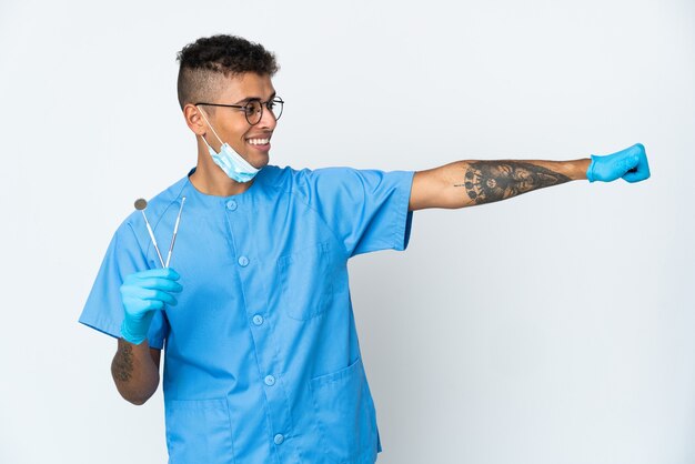 Dentista brasileño sosteniendo la herramienta en blanco dando un pulgar hacia arriba gesto