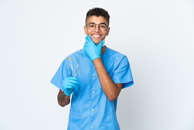 Dentista brasileño sosteniendo la herramienta en blanco feliz y sonriente