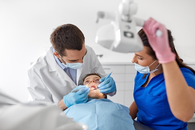 Foto el dentista chequea los dientes de los niños en la clínica dental