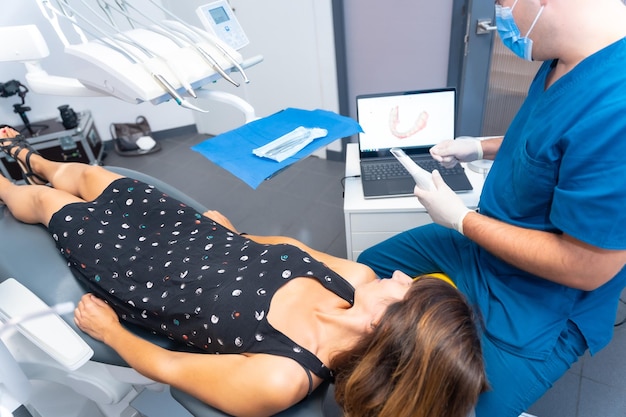 Dentista de la clínica dental realizando un escaneo 3d al paciente con la computadora