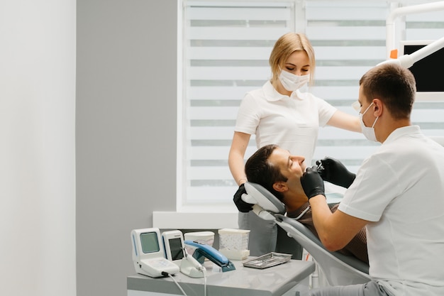 Dentista com um assistente de trabalho em uma clínica odontológica.