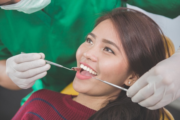 Dentista cuidando paciente femenino