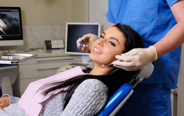 Dentista curando a una paciente en un consultorio dental. Visita de mujer de atención de odontología