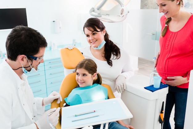 Dentista, dando tratamento odontológico para criança e mãe